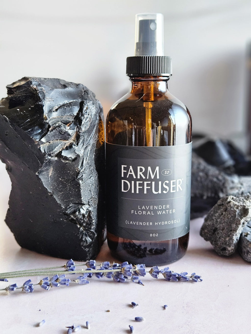 Lavender Floral Water next to a large piece of obsidian collected from the lavender farm in Central Oregon's High Lava Plains