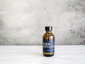 2 ounce amber glass bottle of lavender essential oil on a marble counter