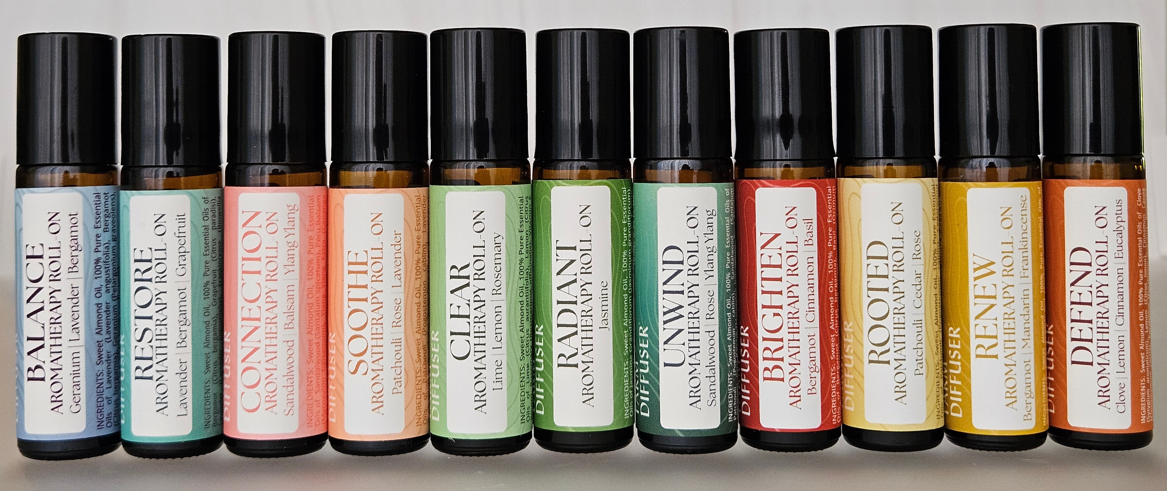 Row of small roller bottles with various colored labels on a light background
