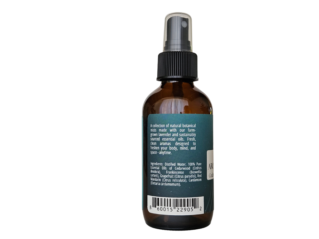 4 fl oz mist bottle showing ingredient label: cedarwood, frankincense, mandarin, grapefruit, cardamom | no synthetic fragrance
